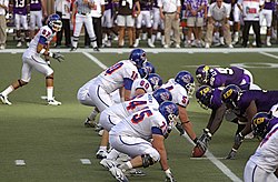Players crouched on either side of a football
