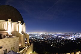 Vista nocturna de la cúpula del observatorio con la Ciudad de Los Ángeles de fondo.