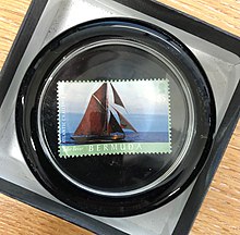 A paperweight containing a Bermudan stamp with a picture of the boat Jolie Brise on it