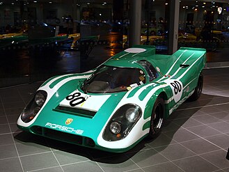 A picture of a green racing sports car from the front in an indoor setting