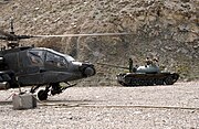 AH-64 počas prestávky na dotankovanie, v pozadí T-62, Afganistan