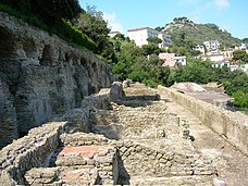 Roman ruins: a walkway with a large structure to the viewer's left