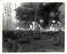 Marine move gas and oil drums away from fire caused by a direct hit by Japanese bombers on a gas and oil dump on Bougainville. 127-GW-1113-68377.tif