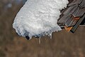 English: Snow on the edge of a wooden roof at the cemetery Deutsch: Schnee am Ende eines Daches am Friedhof