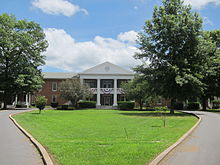 A two-story brick building with a two-story neoclassical portico