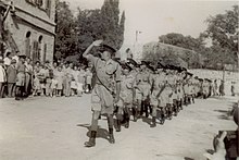 שוטרי ירושלים צועדים בחזית בית הדגל, במהלך טקס השבעתם למשטרת ישראל, 16 באוגוסט 1948. צועד בראש הסמל חיים תבורי, לימים המפכ"ל השישי של משטרת ישראל.