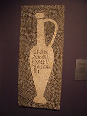 Mosaic depicting a "Flower of Garum" jug with a titulus reading "from the workshop of the garum importer Aulus Umbricius Scaurus" Garum Mosaik Pompeji.JPG