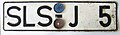 Licence plate with part-plastic (1964); plate and area code are embossed whereas the identifier characters (J 5) are riveted on.