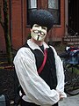 A protester with a V mask and a plastic afro