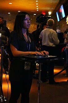 DJ Hero 2 features gameplay based on turntablism, using a special turntable-style controller (being used by a player above) to mimic scratching, crossfading, and freestyle effects. Djhero2 player.jpg