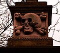 The skull and crossbones gatepost is from the nearby Church of St. Cuthbert with the Mausoleum.