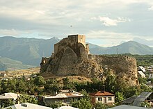 An old fortress, with mountains in the background