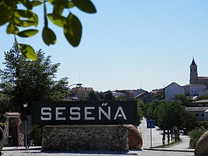 A sign that says Seseña, the name of the municipality, and some small buildings in the background