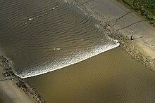 A tidal bore wave moves along the River Ribble between the entrances to the Rivers Douglas and Preston.