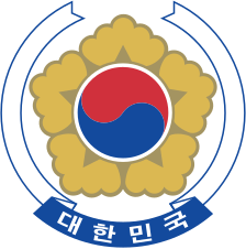 Sydkoreas riksvapen innehåller en frilandshibiskus som är en blomma som växer i Korea. Texten under betyder Republiken Korea.