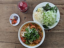 A bowl of bun rieu cua, served with fresh herbs and nuoc mam Bun rieu with herbs.jpg