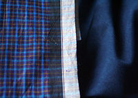 The border of a Bangladeshi lungi, showing the black & white reinforced weave border to minimize fraying LungiBorder.jpg