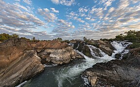 Li Phi falls at sunrise with white and grey clouds in Don Khon Laos