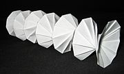 Mathematical origami: Spring Into Action, by Jeff Beynon, made from a single paper rectangle.[185]