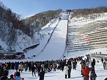 Photographie d'un tremplin de saut à ski lors d'une compétition.