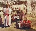 Two Sart men and two Sart boys posed outside, in front of wall, in the early 20th century. (from History of Tajikistan)