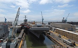 Vue du port de l'USS Carl Vinson, sur lequel on a installé des hangars en tôle démontables et du matériel de construction.