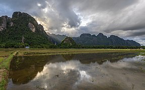 Water reflection of the mountains of Vang Vieng with crepuscular rays