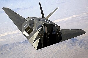 Top view of angular aircraft banking left while flying over mountain ranges