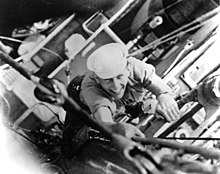 Black and white photograph of Munro climbing a ship's rigging