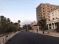 Een nieuw geasfalteerde weg, Democracy Street, en verlaten gebouwen na heropening in 2020 (het witte gebouw aan de rechterkant is de oude kunstacademie).