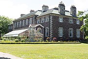 The rear of Government House, greenhouses, and surrounding garden