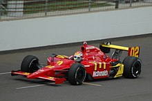 Photograph of Wilson driving a red Dallara-Honda car on a race track