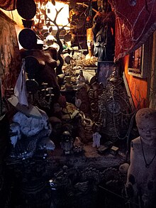 Photograph of a dimly lit collection of dolls and other items