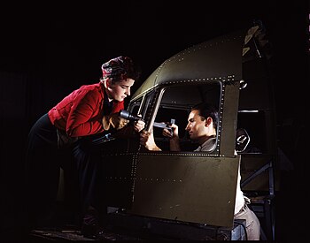 Riveting team working on the cockpit shell of a C-47 transport at the plant of North American Aviation. The woman on the left operates an air hammer, while the man on the right holds a bucking bar. Riveting team2.jpg