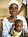 Una nonna liberiana che segue un corso di nutrizione con suo nipote.