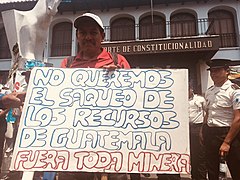 Guatemalan anti-mining protester with sign.jpg