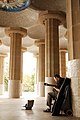 A musician playing among columns of Sala Hipóstila, Park Güell (UNESCO World Heritage Site), hill of El Carmel, Gràcia (district), Barcelona, Catalonia, Spain