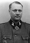 A man wearing a military uniform with an Iron Cross displayed at the front of his uniform collar.