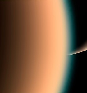 Close view of Titan with Saturn in the background.