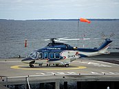 Copterlinen helikopteri rakennuksen yhteydessä sijaitsevalla helikopterikentällä.