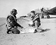 Two aircrew examining a target drogue at No. 10 Bombing and Gunnery School, RCAF, Mount Pleasant, P.E.I., 1944 Airmen+TargetDrogueRCAFMountPleasantPEI1944.jpg