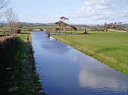 The canal at Farleton, Cumbria, in the unnavigable northern section. The building on the left was used as stables for the packet boat services. Lancaster Canal Farleton.JPG