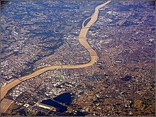 Vue très large de Bordeaux. On aperçoit les deux rives de la ville et la Garonne la traversant en formant une courbe.