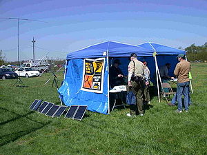 Solar-powered Amateur Radio Station in tents with portable VHF/UHF satellite and HF antennas in the background Camporee.JPG