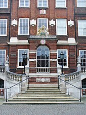 A red brick building in the Georgian style. A staircase at the front leads up to the front door.