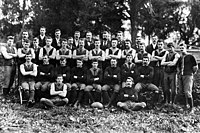 A group of young men with arms folded posing for a team photograph