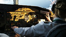 A first officer at the controls of a de Havilland Canada Dash 8 passenger aircraft Wideroe-dash8-cockpit.jpg