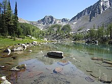 A very clear lake with mountains in the background