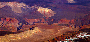 View showing hardened flows of dark volcanic rock descending over the side of a canyon