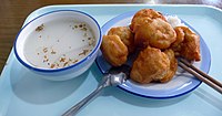 Peking-style xingren doufu (left) with sprinkled dried osmanthus flower in a restaurant in Beijing, China. Peking-style cream fried dough (Nai You Zha Gao ) on the right. Xing Ren Dou Fu Nai You Zha Gao .JPG